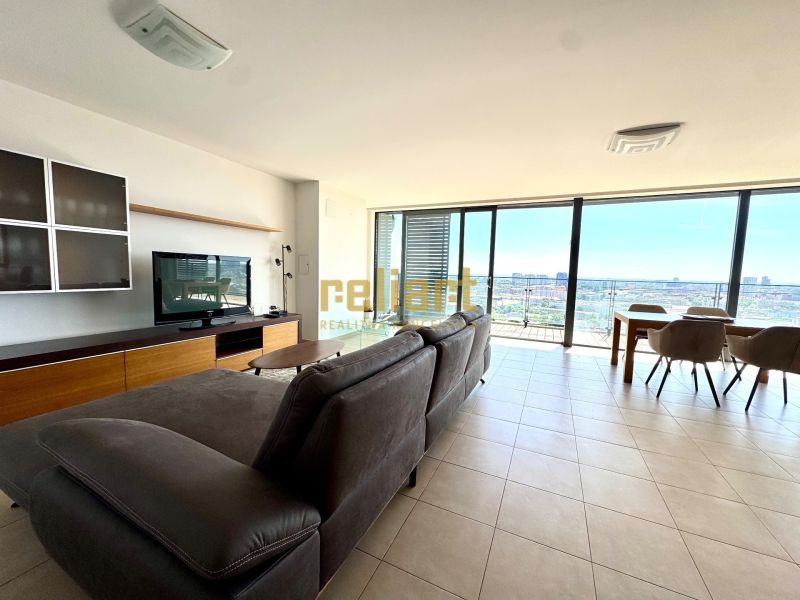 Světlý obývací pokoj s pohovkou, TV a velkými okny, 4pokojový byt.