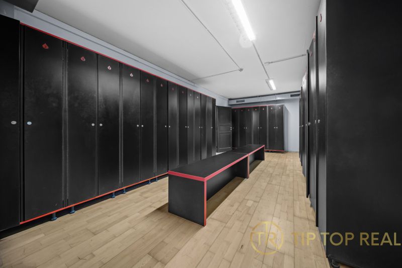 Černé skříňky, lavice s kontrastním designem, podlaha s dřevěným dekorem v obchodních prostorech.