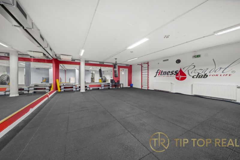 Fitness prostor s boxovacím pytlem a zrcadly.