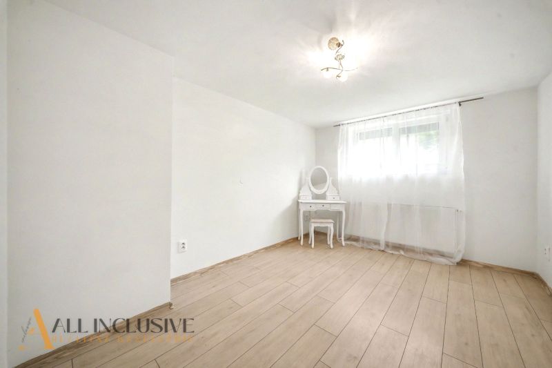 Pokoj s podlahou s dřevěným dekorem a toaletním stolkem v rodinném domě.