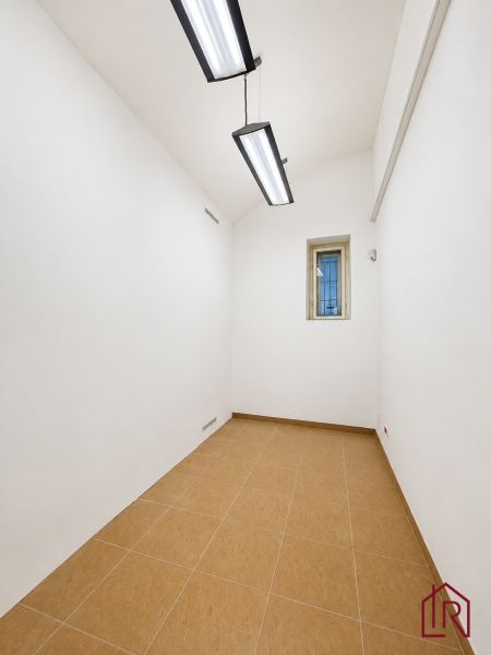 Bílé stěny, malá místnost, stropní svítidla, dlažba, kanceláře.