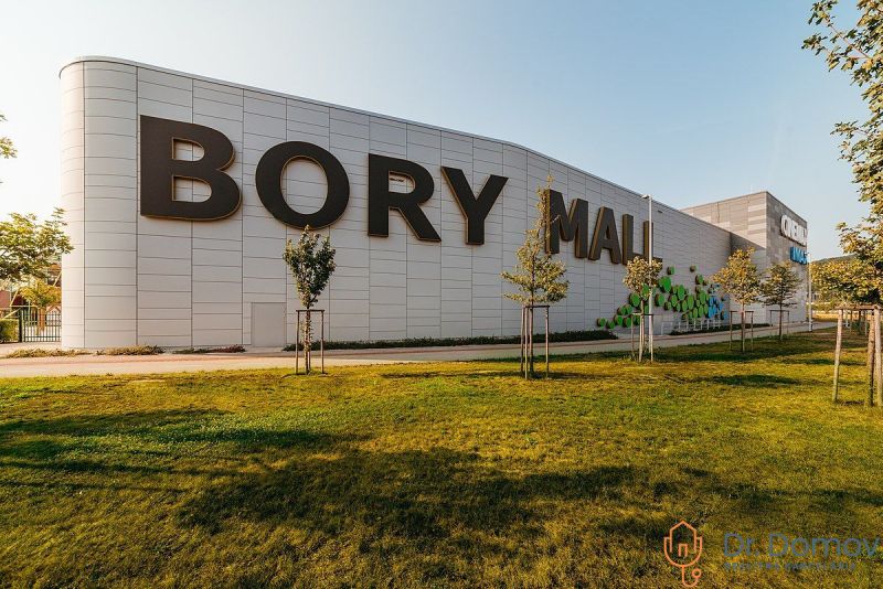 Nákupní centrum Bory Mall s nápisem, travnatá plocha a stromy v Bratislavě-Lamači.