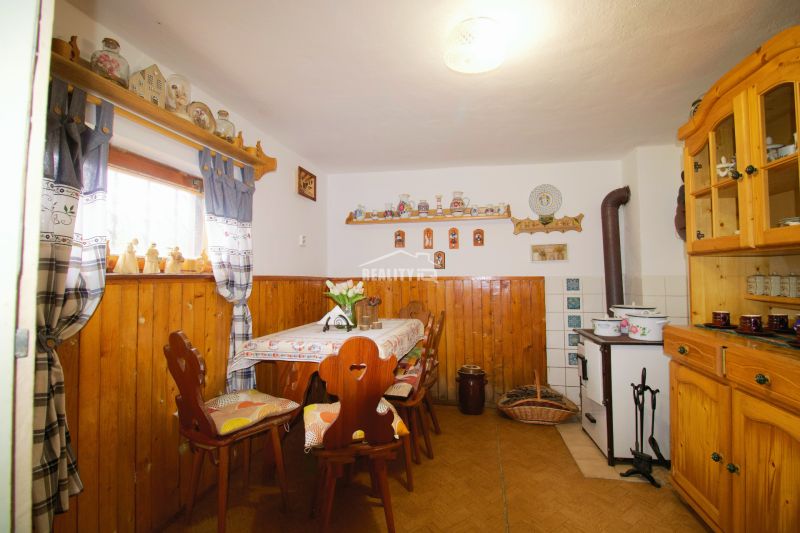 Interiér chaty s rustikálním nábytkem a dekoracemi, podlaha s dřevěným dekorem.