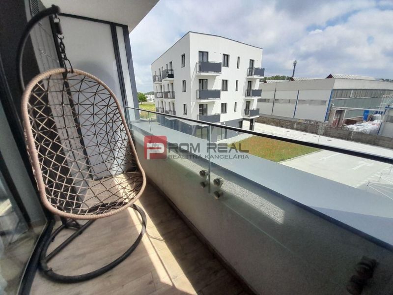 Balkon 2-pokojového bytu na Slunečnicové v Rovince s houpačkou a výhledem na okolí.