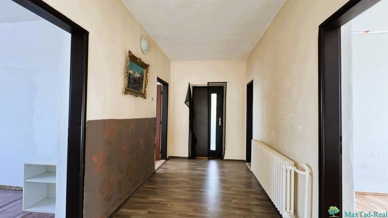 Chodba v rodinném domě s podlahou s dřevěným dekorem a obrazem na stěně.