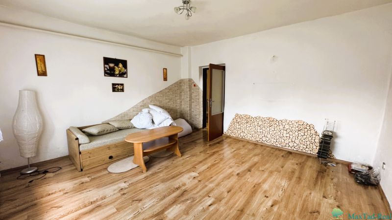 Obývací pokoj v rodinném domě s pohovkou a podlahou s dřevěným dekorem.