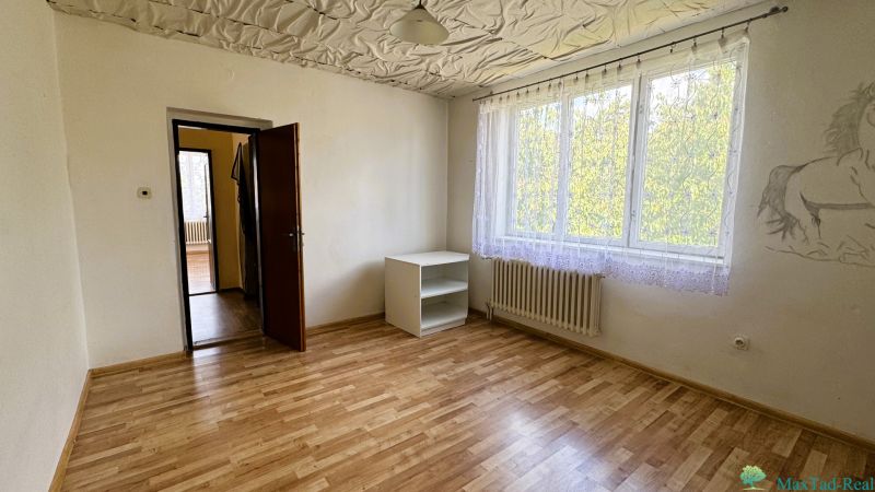 Pokoj s podlahou s dřevěným dekorem, skříňkou a malbou na stěně v rodinném domě.