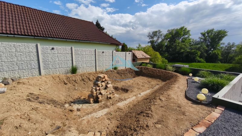 Dvůr s výkopem a hromadou cihel na Rekreačních pozemcích na Selešťanech v Záhorcích.