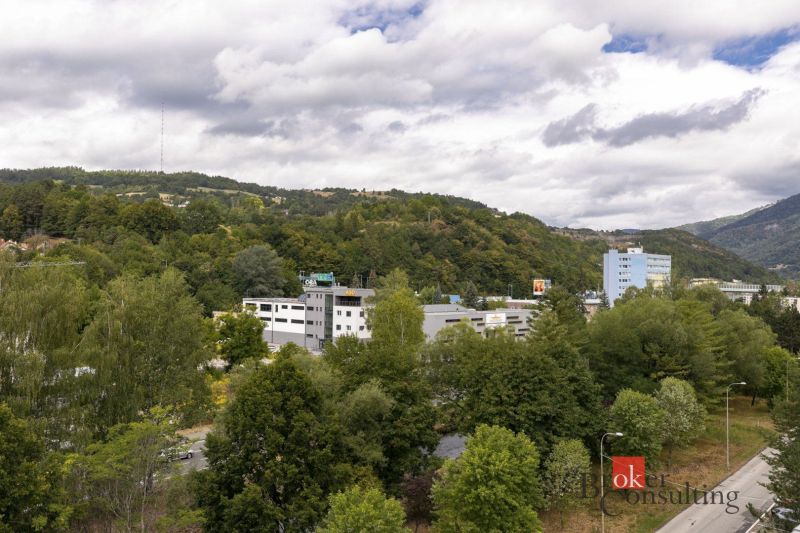 Výhled na zeleň a budovy v Banské Bystrici na Severní ulici, obklopené kopci.