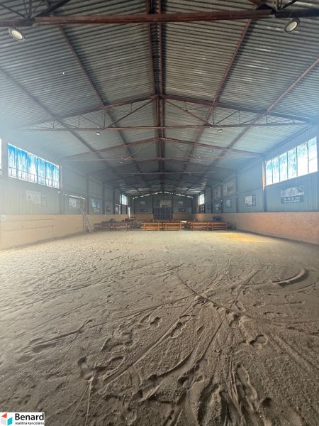 Interiér budovy s velkým prostorným hřištěm a kovovou střechou.