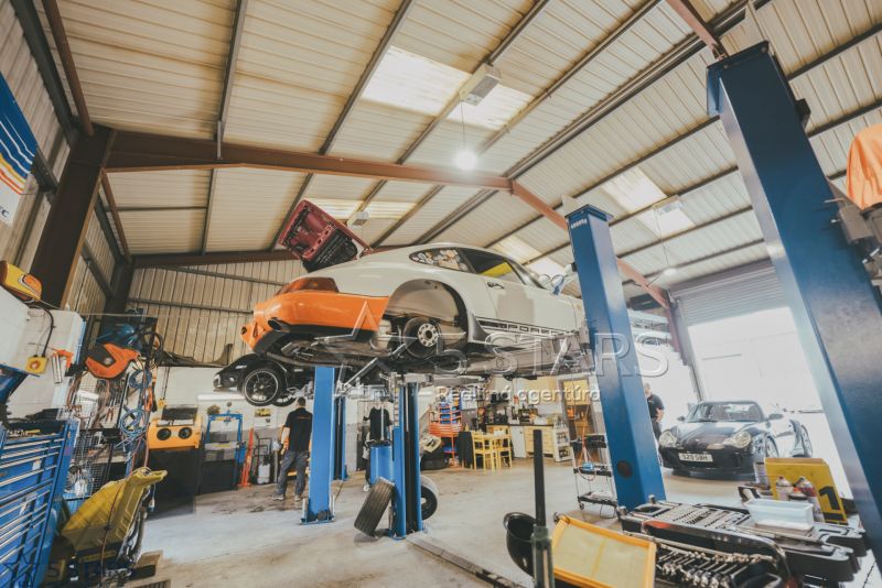 Autoservis se dvěma zvedáky, vozidly a nářadím v prostoru zvláštních nemovitostí.