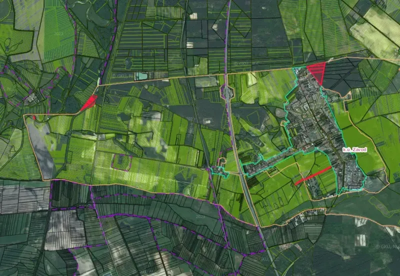 Letecký pohled na zemědělské a lesní pozemky v obci Závod se silniční infrastrukturou.