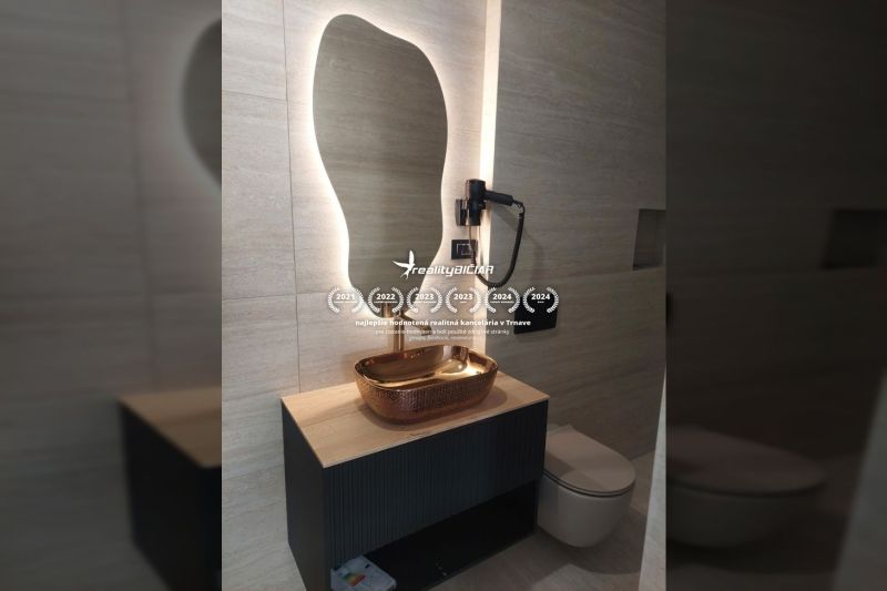 Koupelna s moderním světlem, zrcadlem a designovým umyvadlem ve vile.