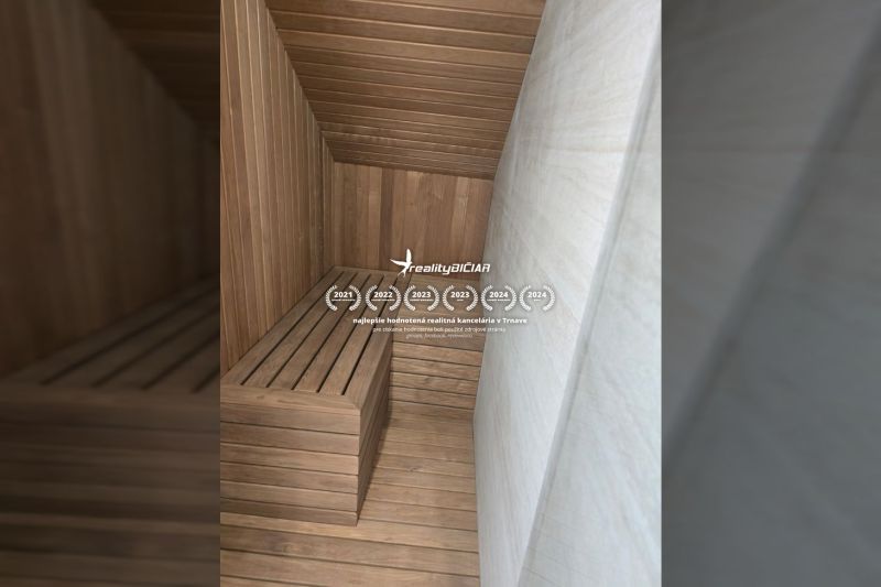 Sauna v interiéru vily s dřevěným obkladem a lavicemi.