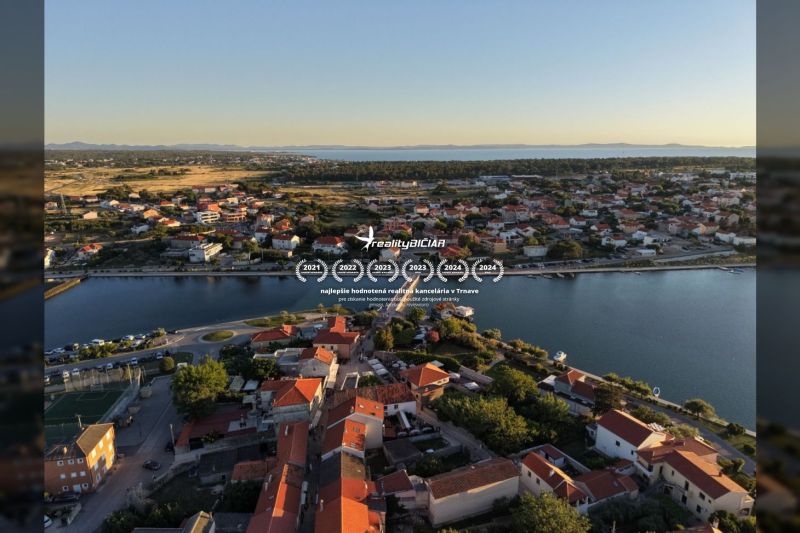 Letecký pohled na město Nin s vilami podél pobřeží a panoramatem moře.