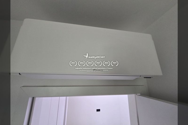 Klimatizace na stěně v interiéru vily s bílým designem a hladkým povrchem.