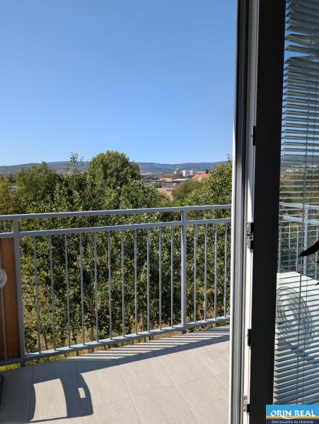 Výhled z 2pokojového bytu v Pezinku na ulici Mahulanka zahrnuje balkon a stromy.