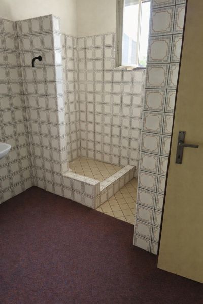 Koupelna v rodinném domě s retro obklady a sprchovým koutem.