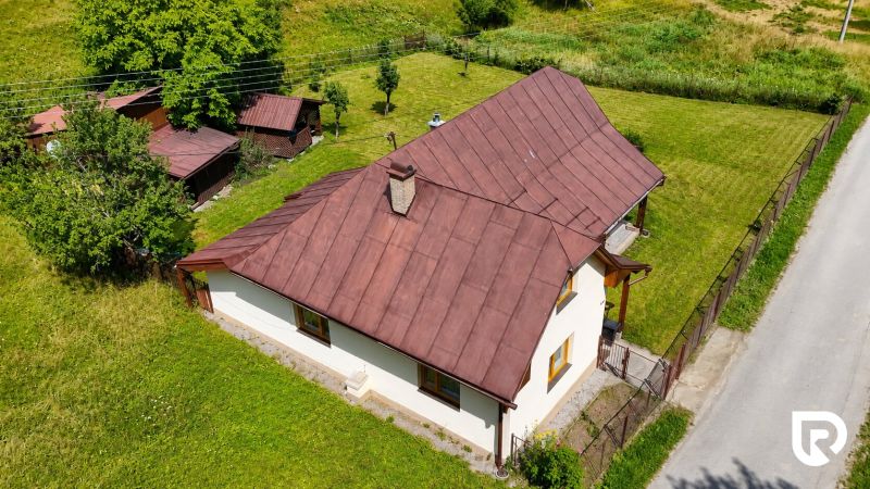Rodinný dům v Makově na Černém nabízí zahradu s dřevěnými přístřešky a stromy.