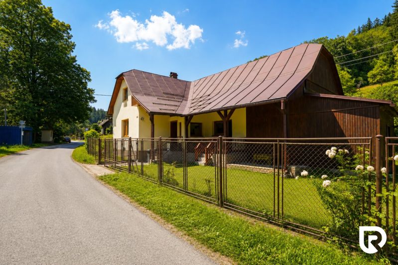 Rodinný dům v Makově na ulici Čierne s plotem a upravenou zahradou.