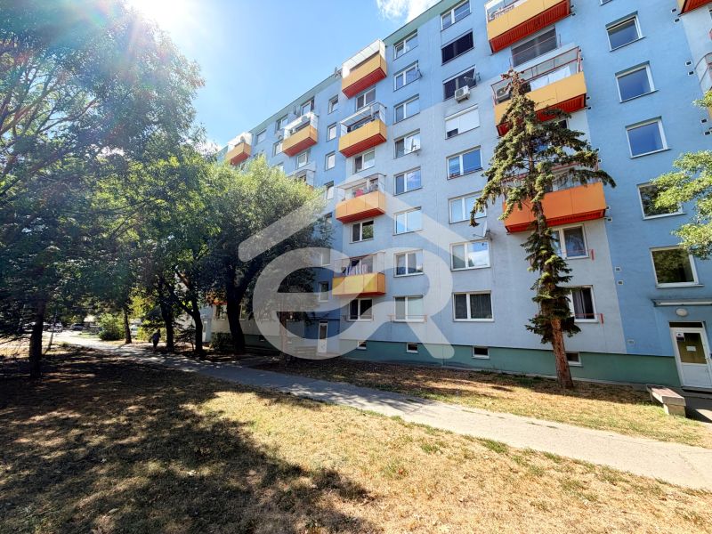 Panelový bytový dům na ulici Lúky ve Vráblech s oranžovými balkony.