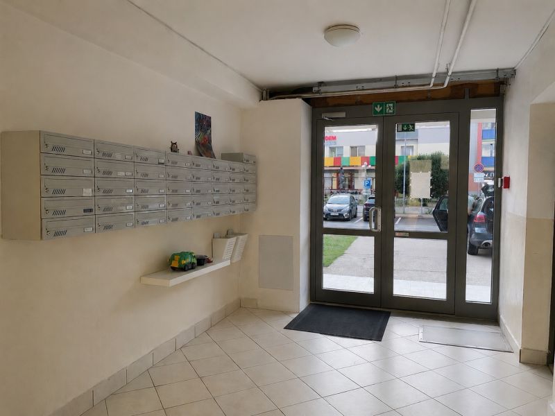 Vstupní hala 3pokojového bytu s poštovními schránkami a prosklenými dveřmi.