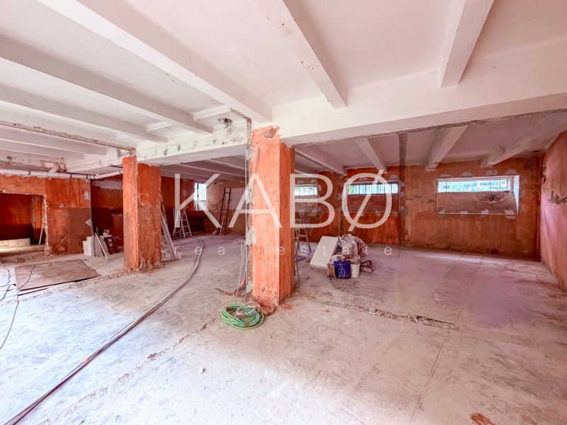 Prostorné obchodní prostory s betonovými stěnami a podlahou, příprava na rekonstrukci.