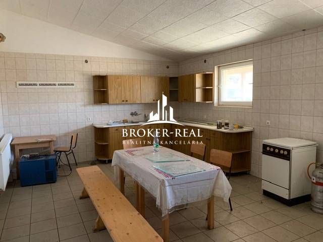 Interiér skladů a hal s vybavenou kuchyní, jídelním stolem a židlemi.