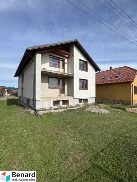 Rodinný dům v Plavnici se zeleným trávníkem a částečně dokončenou fasádou.