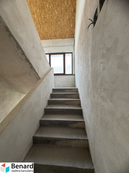Betonové schodiště vede k oknu, podhled z OSB desek, Rodinný dům.