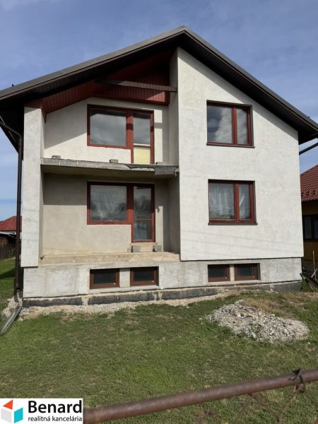 Rodinný dům v Plavnici s jednoduchou fasádou a novými okny, s travnatým pozemkem.