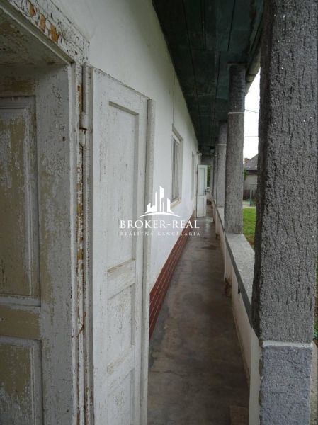 V Černochově, rodinný dům s dlouhým chodbovým balkonem a sloupy.