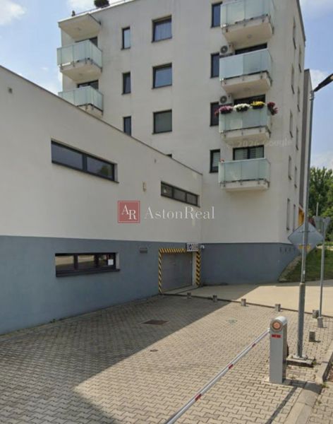 Budova s garáží na Švermově ulici v Banské Bystrici, parkovací sloupky.