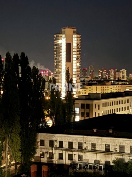 Večerní pohled na osvětlený výškový dům v Bratislavě, Novém Městě na Sliačské ulici.