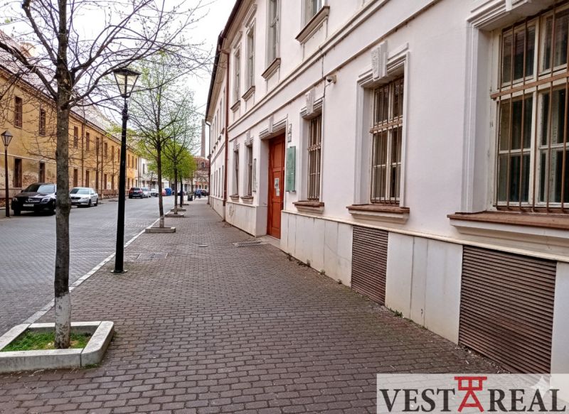Ulice Františkánská v Trnavě s historickými budovami a stromy u kanceláří.