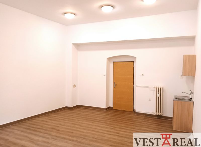 Kanceláře s podlahou s dřevěným dekorem, bílými stěnami a umyvadlem.