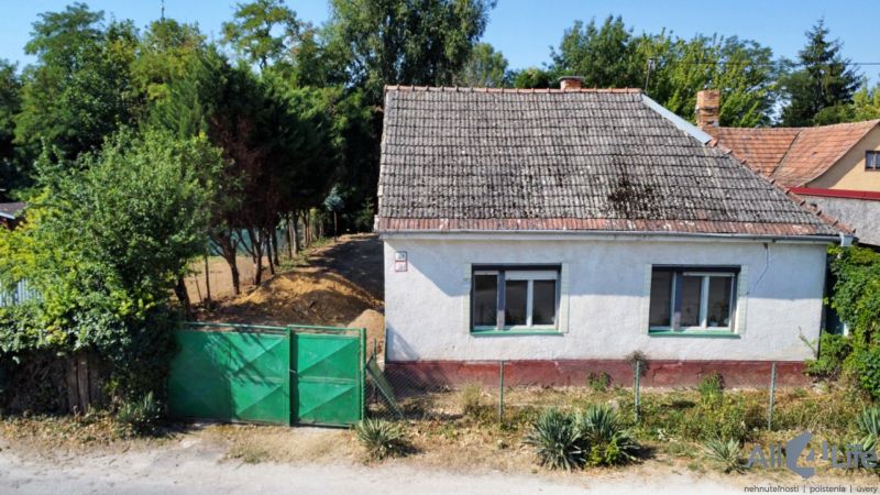 Rodinný dům na Náměstí sv. Floriána v Krakovanech, obklopený zelení a plotem.