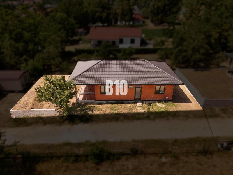 Rodinný dům v Čeľadiciach s cihlovou fasádou, šikmou střechou a oplocením.