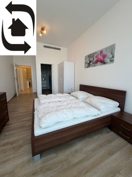 Ložnice s podlahou s dřevěným dekorem a postelí v 3-pokojovém bytě.