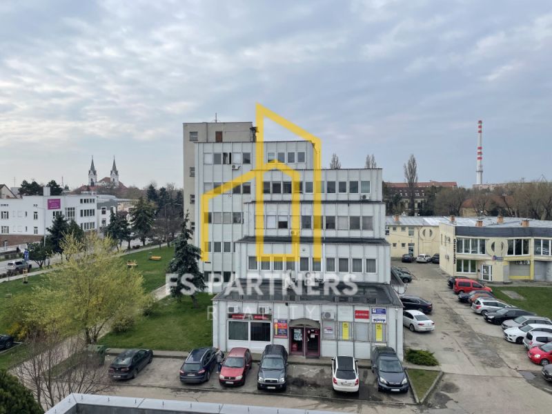 Kancelářská budova na Záhradnícké ulici v Komárně s parkovištěm a zelení.