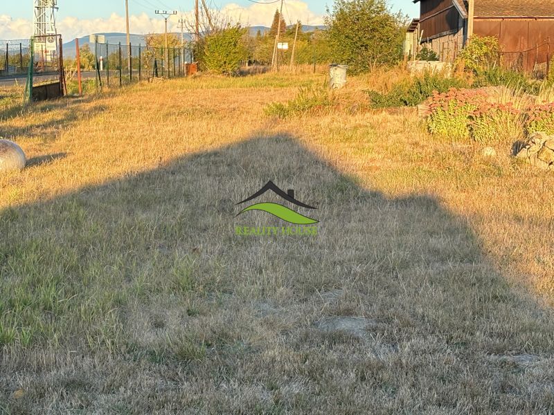 Zahrada u rodinného domu v Blatných Revištích s travnatým porostem a oblohou v pozadí.