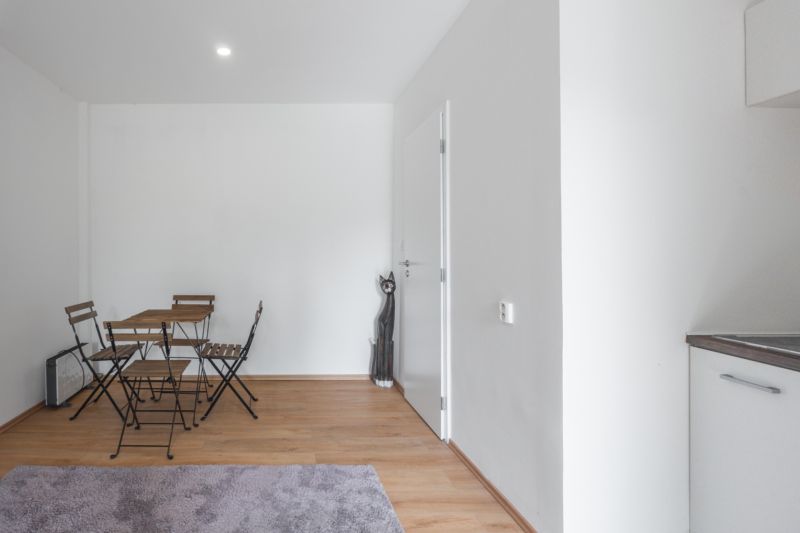Jednoduchý interiér s dřevěným stolem a židlemi na podlaze s dřevěným dekorem.