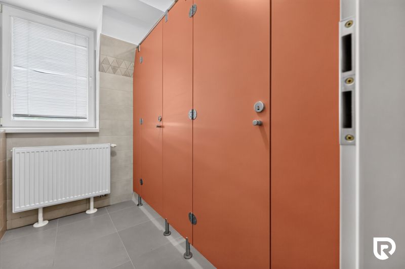 Oranžové kabinky s dveřmi na veřejných toaletách v kancelářích.