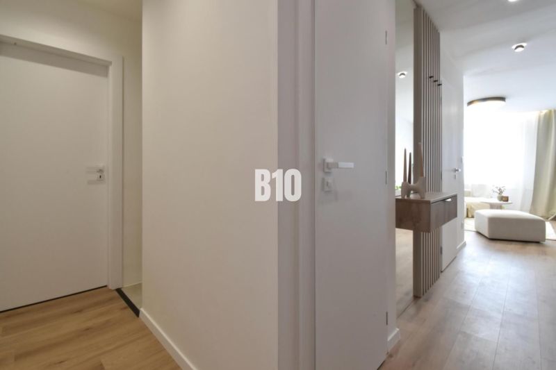 Interiér 4-pokojového bytu s podlahou s dřevěným dekorem a minimalistickým nábytkem.