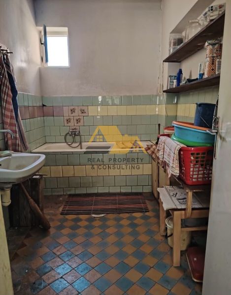 Koupelna v rodinném domě s mozaikovými obklady a vanou, na dřevěném dekoru.