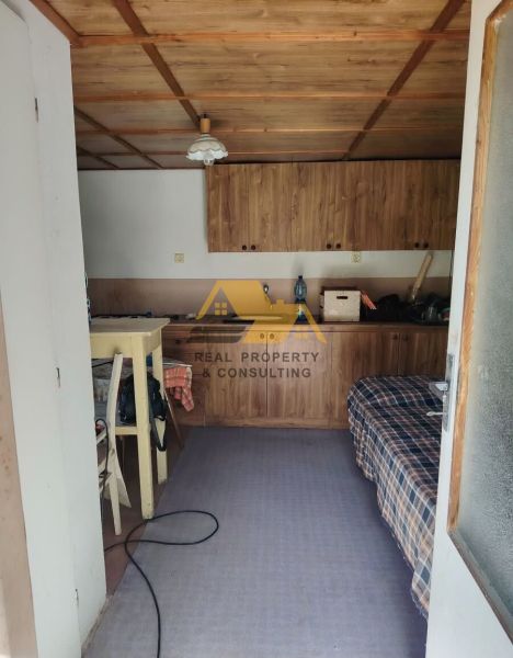 Interiér garáže s dřevěnou kuchyňskou linkou a stropem v rodinném domě.