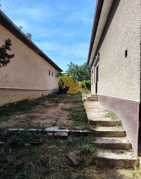 Rodinný dům v Tvrdošovcích s dvorem, kde vedou schody mezi dvěma budovami.