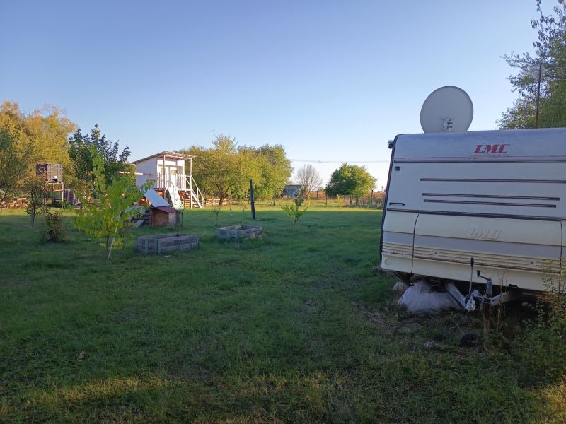 Karavan v zahradách na Tatranské 201 ve Zlatých Moravcích obklopený stromy a trávou.