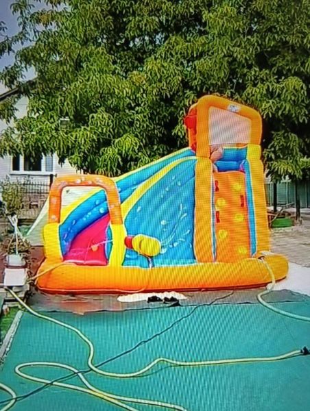 Nafukovací atrakce na zahradě ve Zlatých Moravcích s houpačkou a skluzavkou.