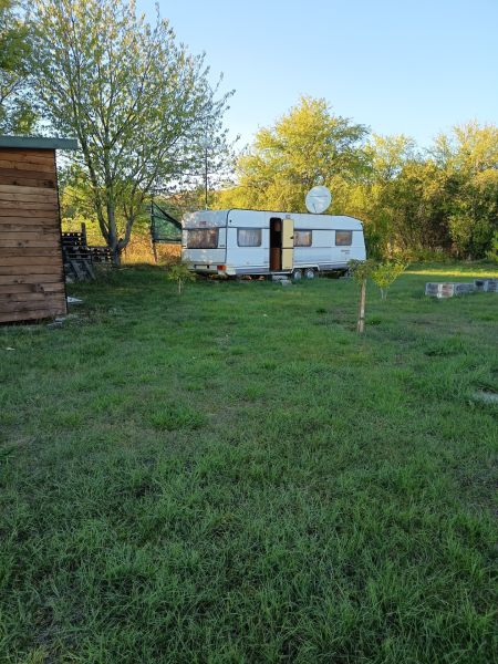 Karavan v zahradách na Tatranské ulici ve Zlatých Moravcích obklopený stromy a travnatou plochou.